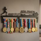 Fekete acél balatonos futós éremtartó skandináv stílusú szobában, fehér falon