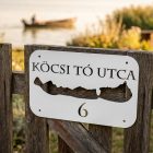 Balatonos alumínium házszámtábla balatoni nyaraló homlokzatán, napsütéses időben