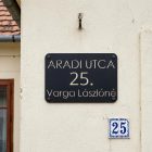 Fekete alumínium utcanév tábla házszámmal, ház homlokzatára szerelve