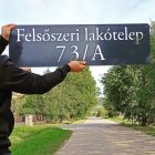 Méteres acél utcatábla modern irodai bejáratnál, ipari loft stílusú térben, téglafalon