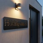 Méteres acél utcatábla modern irodai bejáratnál, ipari loft stílusú térben, téglafalon