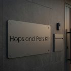 Fehér fém cégtábla rendelő bejáratának ajtaján, kültéri elhelyezés