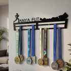 Balatonos futóverseny érmei akasztva fekete acél éremtartón, edzőszoba fal 