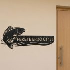 Fehér alumínium házszám tábla macskaszilhuettel, fa bejárati ajtó mellett rögzítve