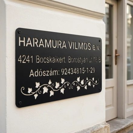 Fekete fém cégtábla adatokkal egy irodaajtó melletti világos falon